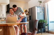 © DusanJelicic - Young multi ethnic couple sitting at the kitchen table, using a laptop to discuss domestic bills and finances, collaborating on managing their household budget and expenses