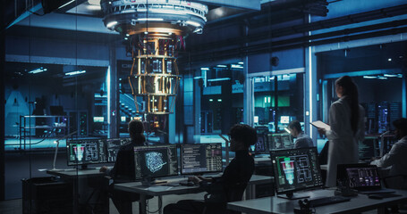 Female Computer Engineer Walking Up to Examine a Quantum Computer in a High Tech Scientific Laboratory. Professional Scientist Making Research and Development Notes in Her Tablet Computer