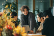 © boyhey - A group of Japanese business people meeting and discussing in an office.