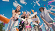© Довидович Михаил - Group of cheerful high school students throwing colorful confetti in the air, celebrating graduation or end of school year
