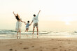 © Charnchai saeheng - Family jumping happiness with their hands raised like a freedom, having fun on the beach with family during a holiday, travel, long weekend, summer or any other holiday.