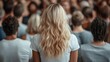 ©  Shomixer - A full view of a person with flowing blonde hair standing in front of a diverse crowd, illustrating themes of connection, individuality, and collective experience in a modern setting.