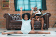 © chokniti - Heartwarming family moment as an African American father and daughter share playful time together on the couch, surrounded by love, laughter, and the warmth of home, while mom gently looks on with joy