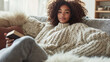 © sabyna75 - Cozy autumn vibes: woman relaxing in knit sweater with book on sofa