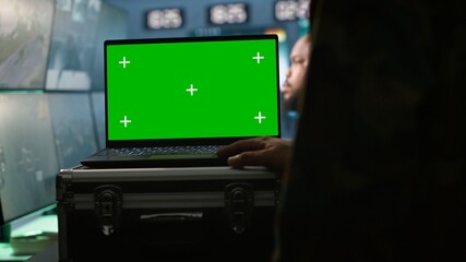 Military agent working in control room, using isolated screen software on laptop, analyzing aerial reconnaissance data. Intelligence corps expert controlling drones with mockup notebook, camera A