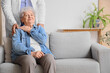 © Pixel-Shot - Senior woman with doctor sitting on sofa at home