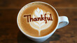 © Gustav - Overhead Shot of a Thanksgiving-Themed Latte with Thankful Written in the Foam, a Heart Shape Design, and a Warm and Inviting Atmosphere for the Holidays