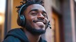 © SY - Happy man listening with headphones outdoors in the city. Perfect for technology, customer service, or music-themed projects.