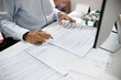 © Lek - asian businessman working on desk reading and checking financial documents and business contract to make new business plan