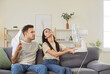 © Studio Romantic - Family couple, woman, man enjoying freshness using electric ventilator, cooler to enjoy fresh air blowing from fan, using home appliance, equipment for cooling, improve indoor air, feeling hot
