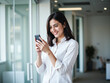 © Stock Image Zone - Smiling Indian or Latin Businesswoman Using Smartphone in Office – CEO or Manager Working Online with Mobile App, Copy Space