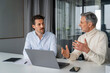 © Westend61 - Two men having a business discussion in an office with a laptop