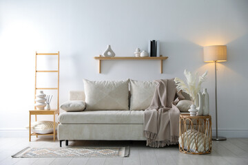Poster - Comfortable sofa with pillows, blanket, lamp and different decor in room. Interior design