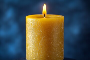 Aufkleber - Yellow candle with a flickering flame against a blue background creating a warm and calming atmosphere