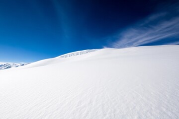 Aufkleber - Roof of a house blanketed in fresh snow, icicles hanging from the edges, and bright sunlight creating a stunning contrast against a vivid blue sky