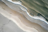 Aerial view of waves washing onto a sandy beach.