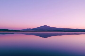 Aufkleber - A still lake mirrors a jagged mountain range as twilight casts soft purple and orange hues, creating a tranquil atmosphere with gentle ripples on the surface
