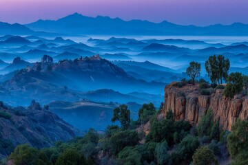 Poster - Majestic mountain landscape at dawn with layers of mist and distant hills in the background