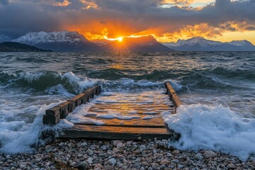 Aufkleber - Sunset over the lake with waves crashing against a wooden dock and mountains in the background