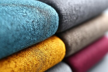 Aufkleber - Textiles stacked in vibrant colors showcasing fabric textures and craftsmanship in natural light