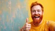 © CRISPIFLY - The middle aged red haired bearded man is smiling broadly as he gives a thumbs up gesture, his eyes crinkled with joy and his whole face radiating happiness