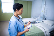 © WavebreakMediaMicro - Mature nurse updating records in hospital room, with clipboard, pen and stethoscope, copy space
