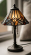 © ABF_MATEO - A quaint, vintage-style lamp with a geometric stained-glass lampshade emits a warm, inviting glow in a cozy interior setting.