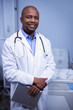 © WavebreakMediaMicro - Middle-aged African American man standing in hospital room near bed, holding laptop and stethoscope