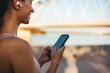 © Dragana Gordic - Woman Using Smartphone Outdoors With Headphones in a Sunny Urban Setting