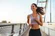 © Dragana Gordic - Smiling Woman Jogging on Bridge During Sunny Morning