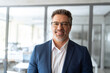 © Stock 4 You - Closeup headshot portrait of indian or latin hispanic mature middle age leader, ceo male businessman in suit in office workplace. Executive confident senior business man specialist smiling at camera