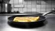 © Premium Graphics - Tortilla Espaola monochrome kitchen scene with a black pan and utensils only the golden yellow slice of Spanish omelette in vibrant color draws attention to the dishs texture for cookbook covers