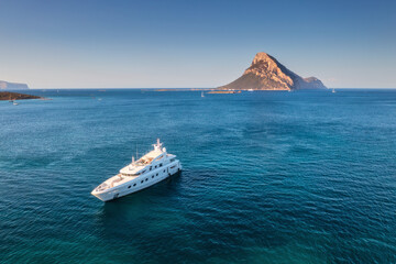 Wall Mural - aerial view of luxury yacht on blue sea at susnet in summer. sardinia, italy. tropical seascape with