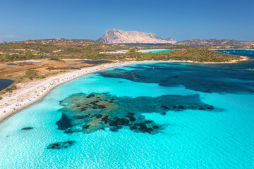 Wall Mural - aerial view of white sandy beach with umbrellas, luxury yachts and boats on blue sea, beautiful isla
