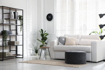 Poster - Stylish shelving unit with decor and sofa in room