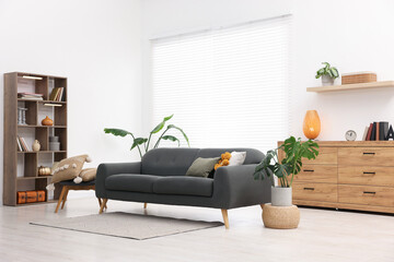 Poster - stylish living room with comfortable sofa and wooden shelving unit. interior design