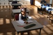 © Wavebreak Media - African American child writing in notebook at school desk with orange pencil and plaid pencil case