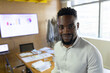 © Wavebreak Media - African American man standing and smiling in conference room, with papers and charts, copy space