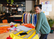 © Wavebreak Media - Young adult woman leaning on worktable with fabrics and thread in modern fashion studio, copy space