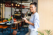 © Wavebreak Media - African American woman holding digital tablet, stylus and smiling in open plan office, copy space
