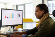 © Wavebreak Media - Mid-adult African American man working on monitors at office desk, with sales charts, copy space