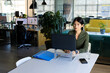 © Wavebreak Media - Asian woman typing on laptop on stand at office table, with blue folder, copy space