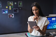 © Wavebreak Media - Woman holding tablet reviewing data charts on monitor in office with inspiration board, copy space