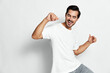 © SHOTPRIME STUDIO - Happy young man dancing wearing white t-shirt and grey pants isolated on plain gray background smiling cheerful casual lifestyle concept