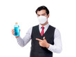 © suphaporn - Confident young Asian man in formal attire wearing medical face mask pointing at blue alcohol bottle, promoting hygiene and safety , isolated on a transparent background during pandemic or health