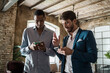 © Lomb - Businessmen networking indoors using smartphones, diverse team collaboration