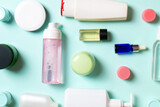 Close-up set of diffrent sized bottles and jars for cosmetic products on colored backgound. Face and body care concept with copy space