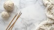 © Pannee - Flat lay of knitting needles with unfinished woolen fabric