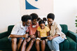 © (JLco) Julia Amaral - Happy Brazilian family watching a video on a tablet at home