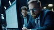 © theo - Intense collaborative analysis: Two professionals examining complex data onscreen